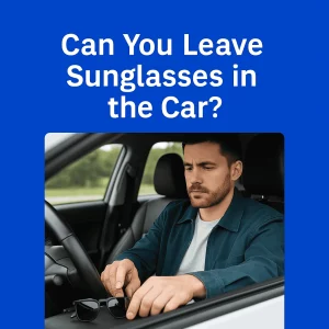 A man in his early 30s with short dark hair and a trimmed beard sits in the driver's seat of a car, placing a pair of black sunglasses on the center console. He wears a dark teal jacket over a white T-shirt and looks serious, with natural daylight coming through the window. Above the image, bold white text on a blue background reads, “Can You Leave Sunglasses in the Car?”
